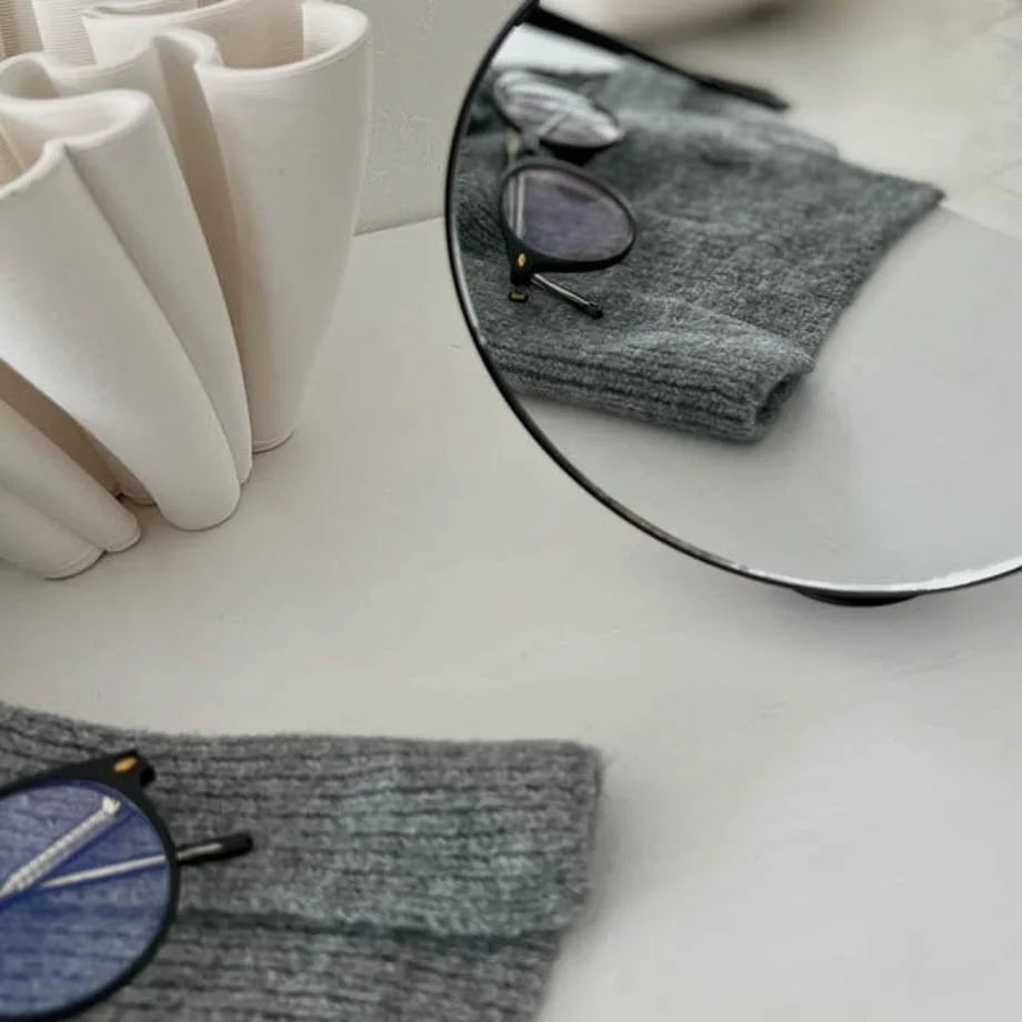 Close-up detail of the clear reflection in the black round desktop mirror.
