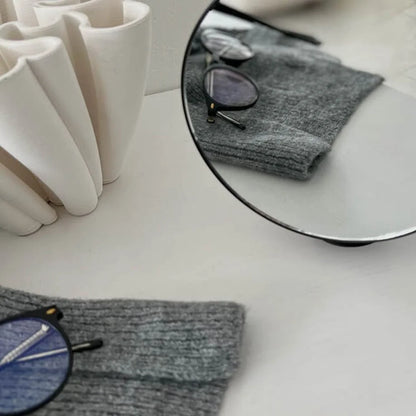 Close-up detail of the clear reflection in the black round desktop mirror.