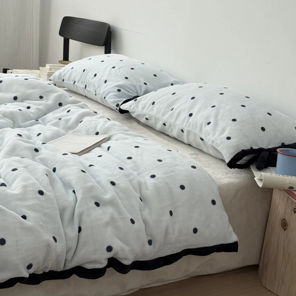 Plush Light Blue Polka Dot Flannel Fleece Bedding Set on a bed with a black headboard - RoomDen.
