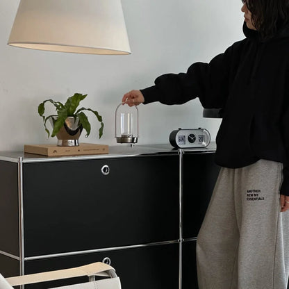 A person holding the Minimalist Arch Metal Table Lamp by its handle in a Japandi-style room. - RoomDen