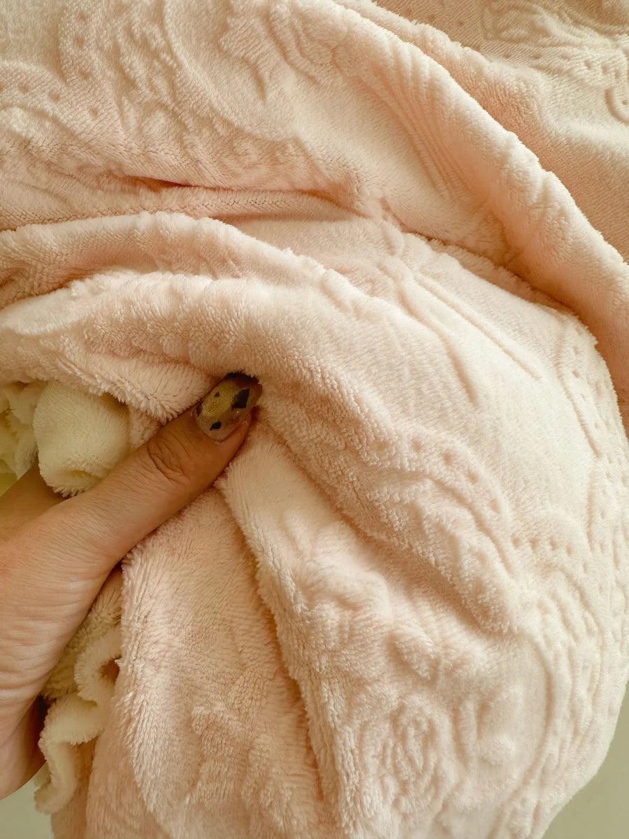 Close-up detail of the soft, plush texture of the Pastel Pink flannel fleece fabric being held - RoomDen.