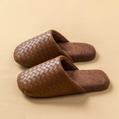Pair of dark brown woven texture slippers with plush lining on beige surface