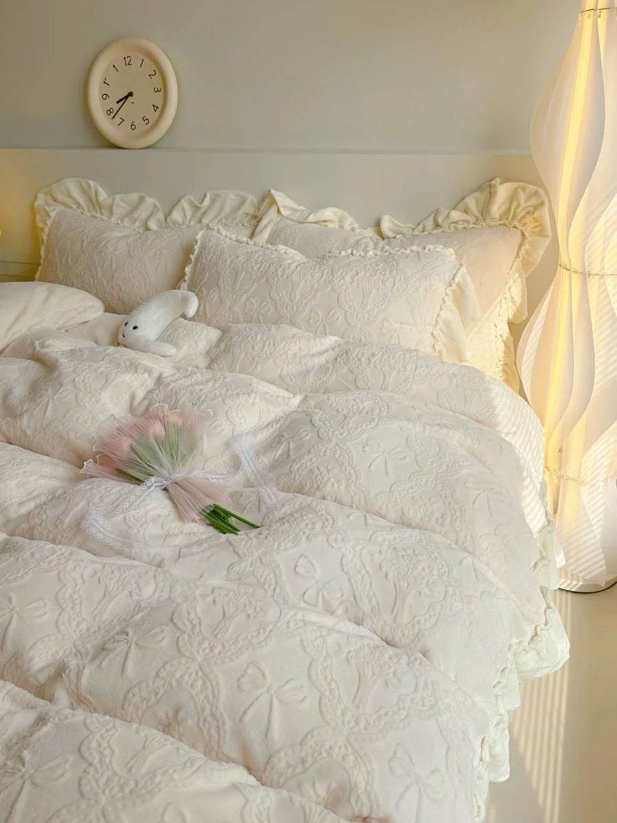 Close-up on the Creamy Beige ruffled pillowcases and duvet cover, highlighting the embossed bow pattern - RoomDen.