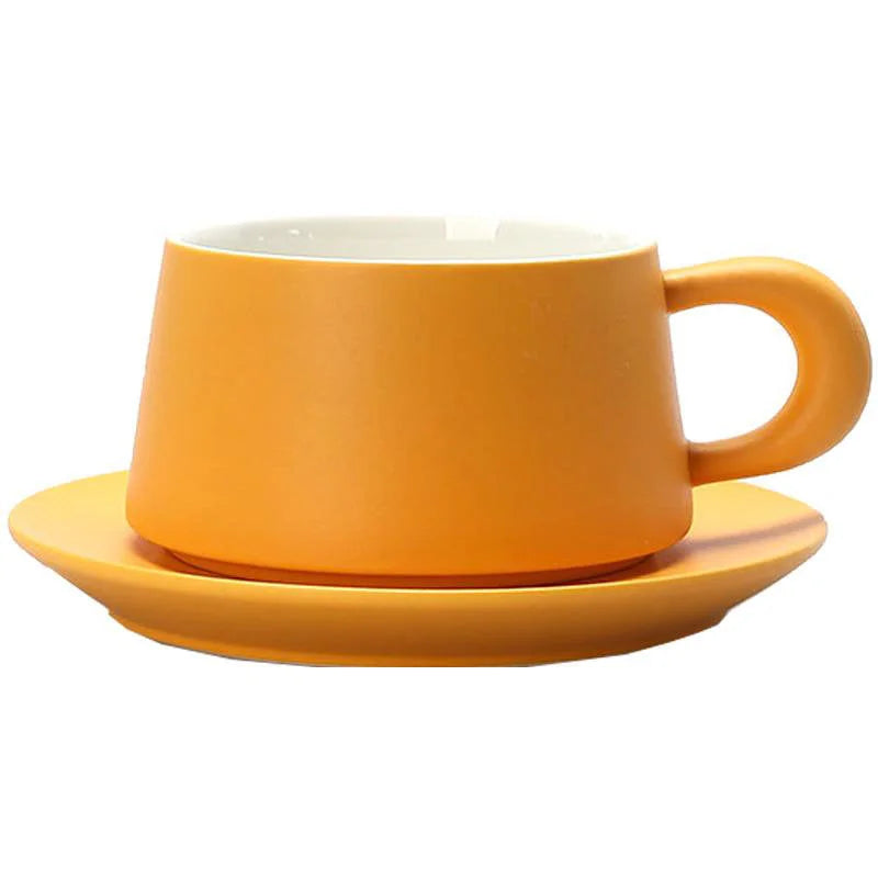 A Marigold Orange matte ceramic coffee cup with a chunky handle and matching saucer on a white background. - RoomDen