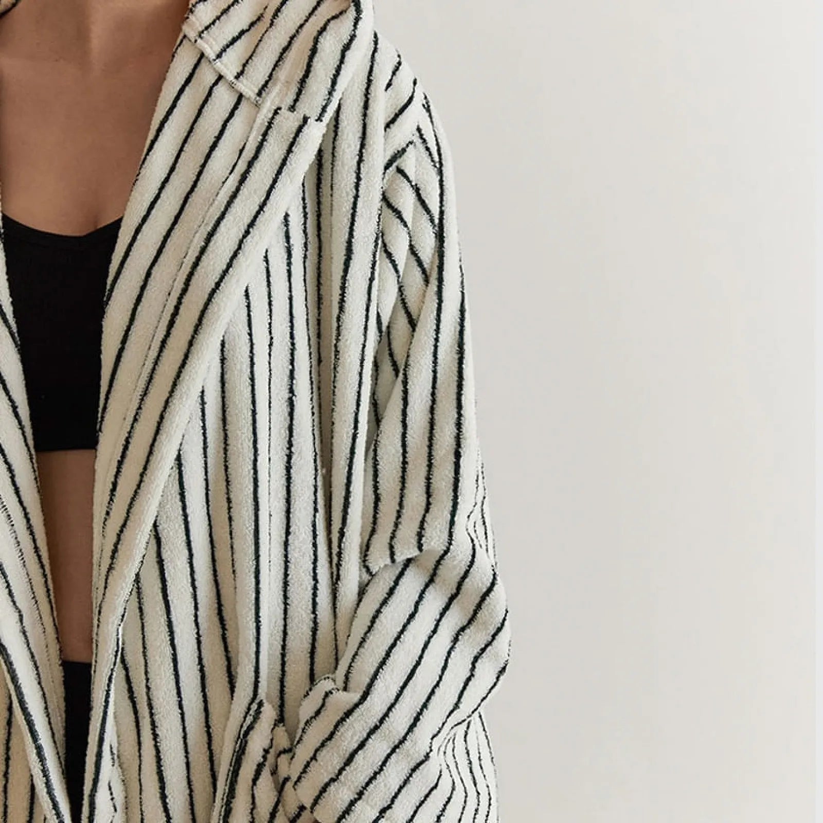 Front detail view of the open robe showing the plush texture and black undergarment contrast.