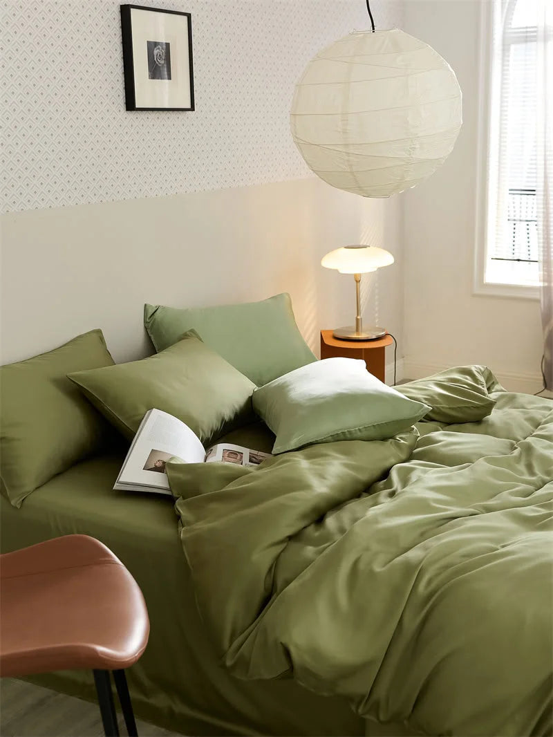 Lifestyle shot of the made-up bed with the olive green Cooling Tencel set, showing pillows and a folded duvet - RoomDen.