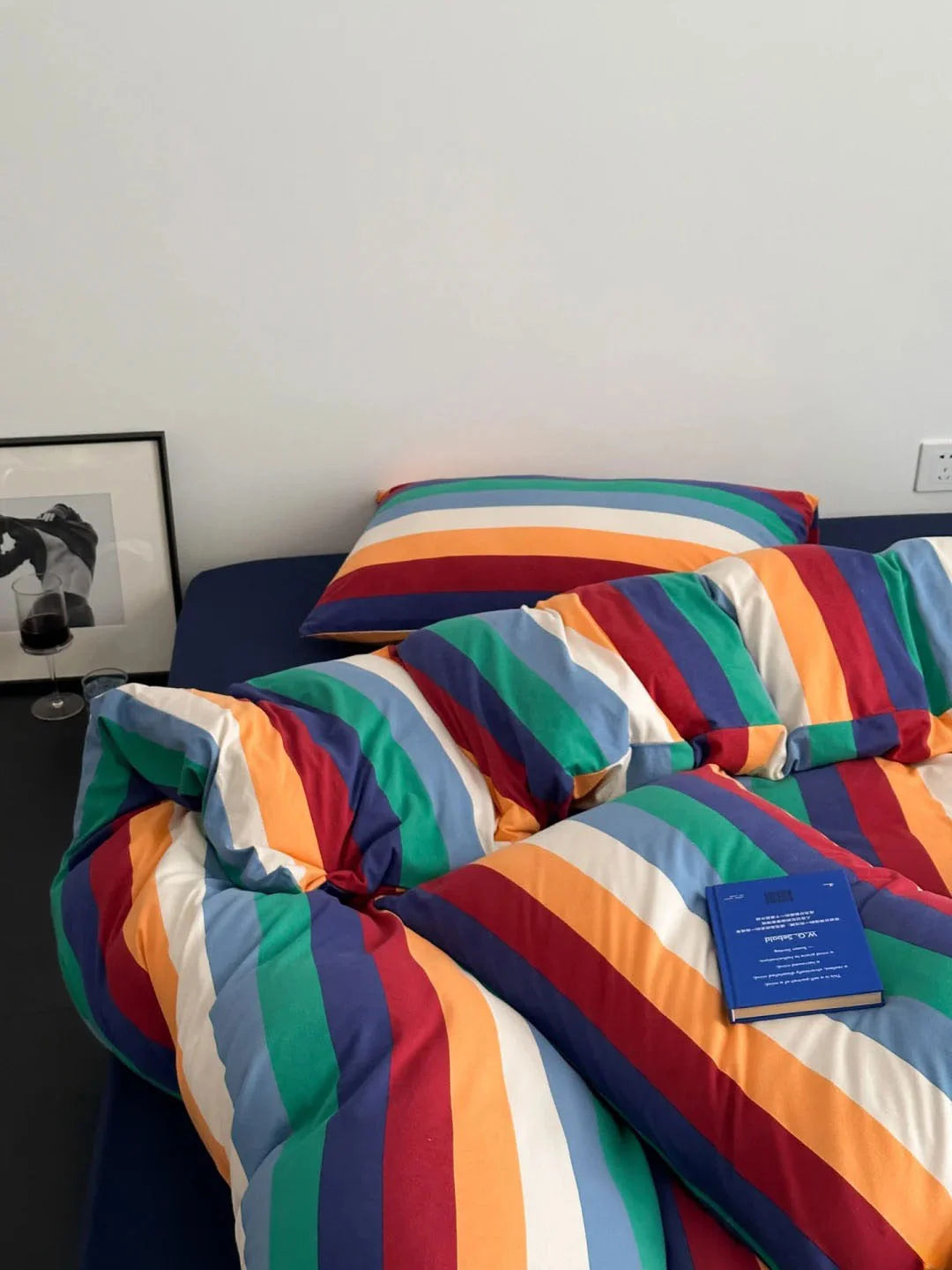 Angled view of the rainbow striped bedding set, creating a cozy and colorful bedroom atmosphere - RoomDen