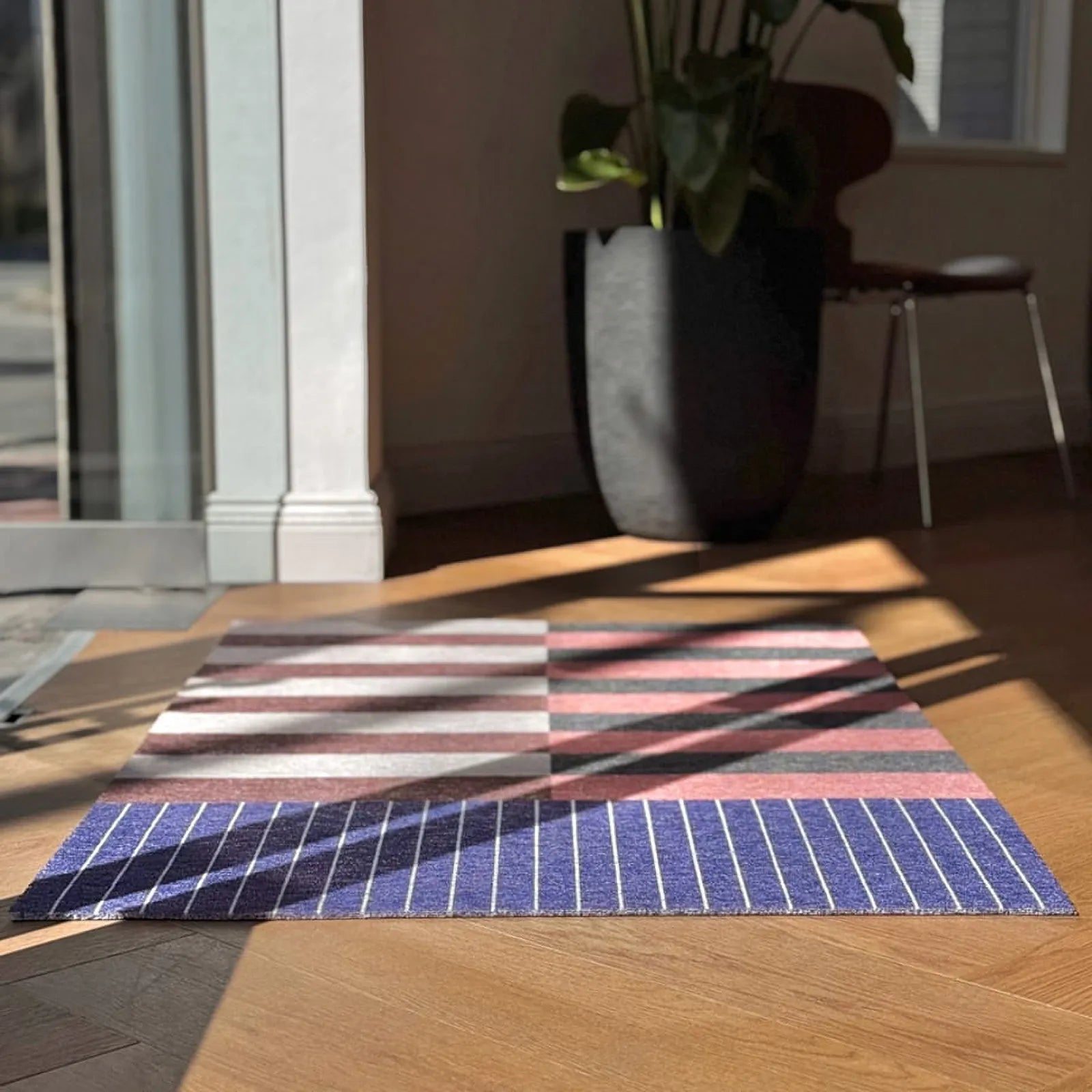 Sunlight hitting the geometric wire loop door mat on wooden floor - RoomDen