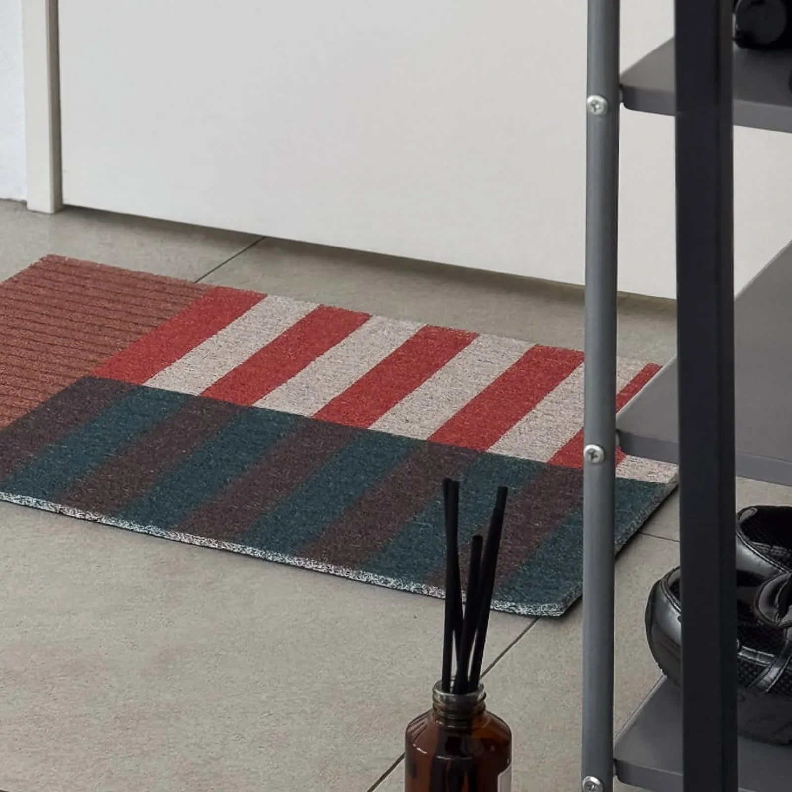 Rust and olive green geometric coil mat placed near shoe rack - RoomDen