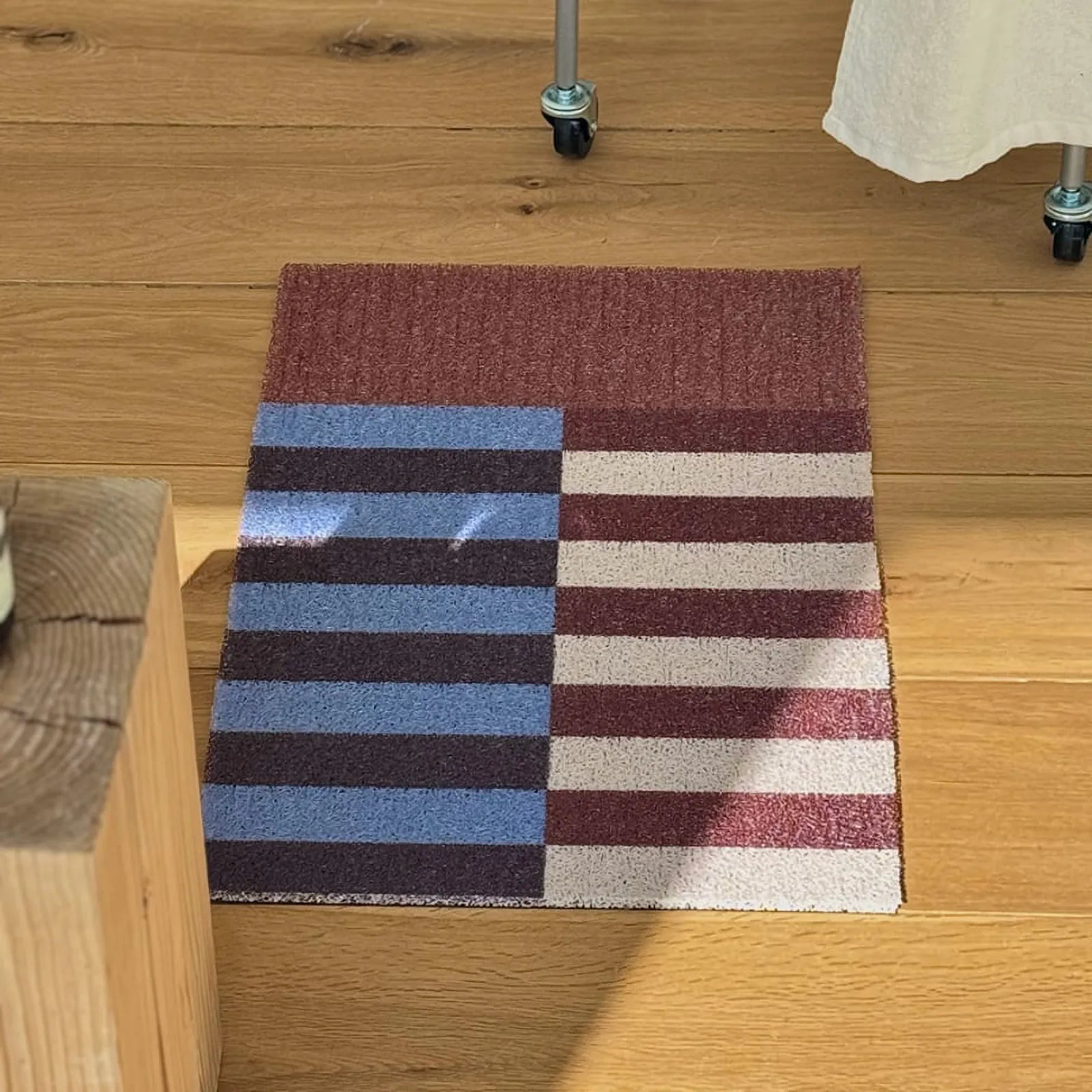 Top view of rust and blue color block mat with sunlight shadows - RoomDen