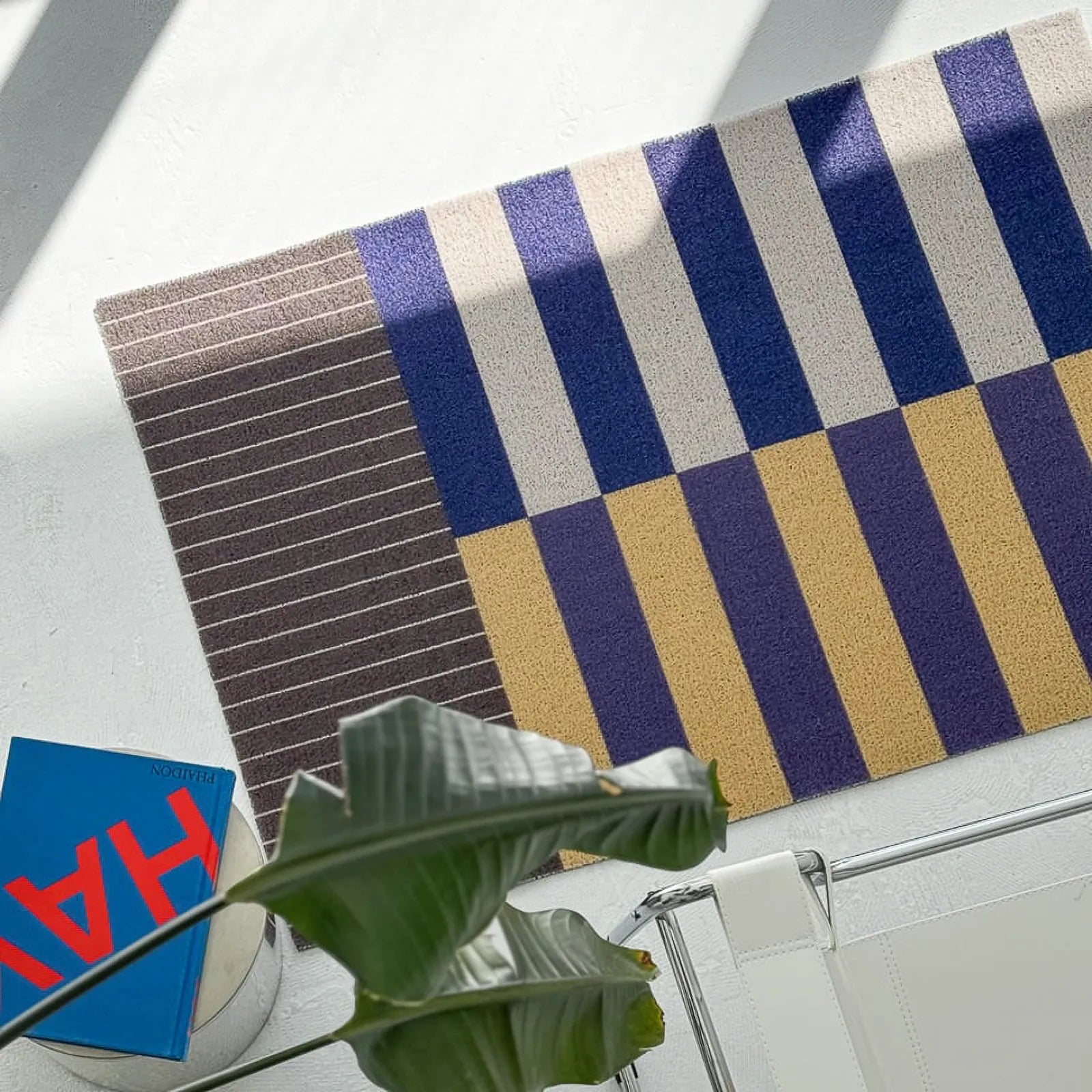 Blue and yellow geometric dirt trapper mat near white chair - RoomDen