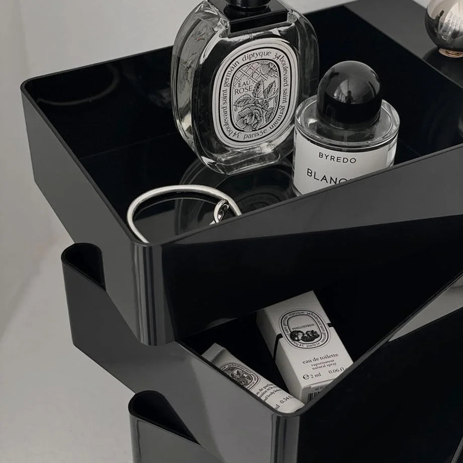 Detail shot of the top two tiers of the Black ABS makeup organizer holding luxury perfume bottles.
