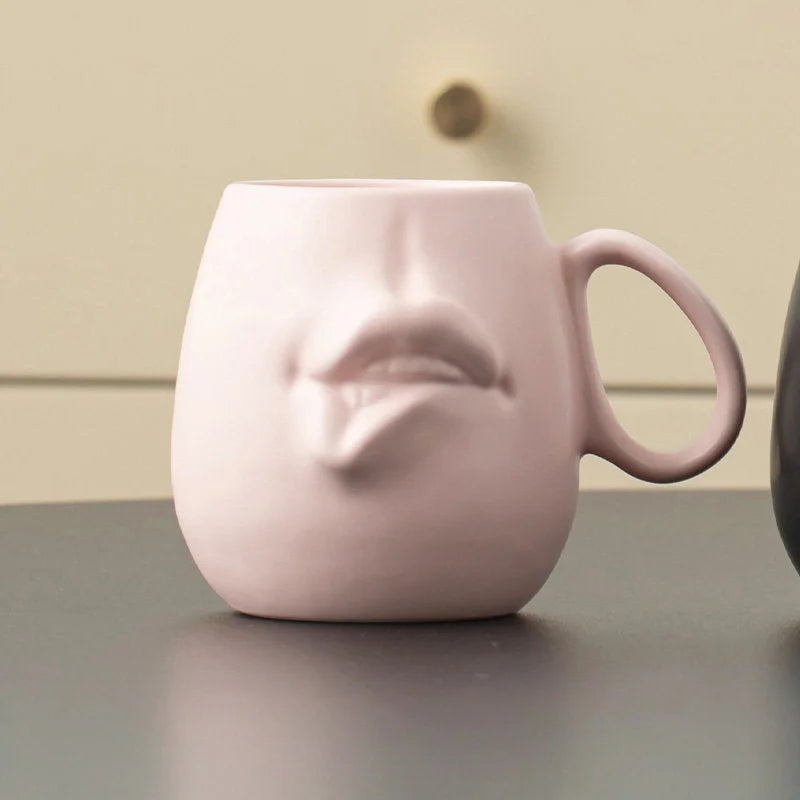 Close-up of the Dusty Pink Sculptural Abstract Face Ceramic Mug on a desk.