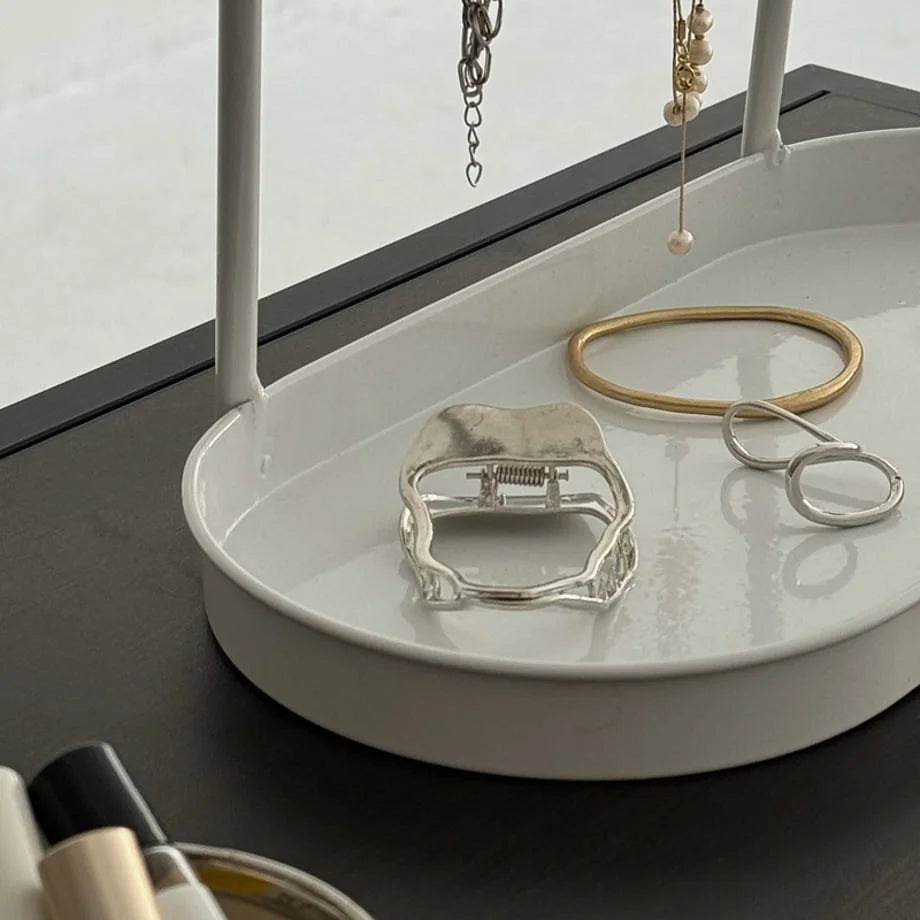 Close-up of the white tray on the jewelry organizer holding a hair clip and bracelet. - RoomDen