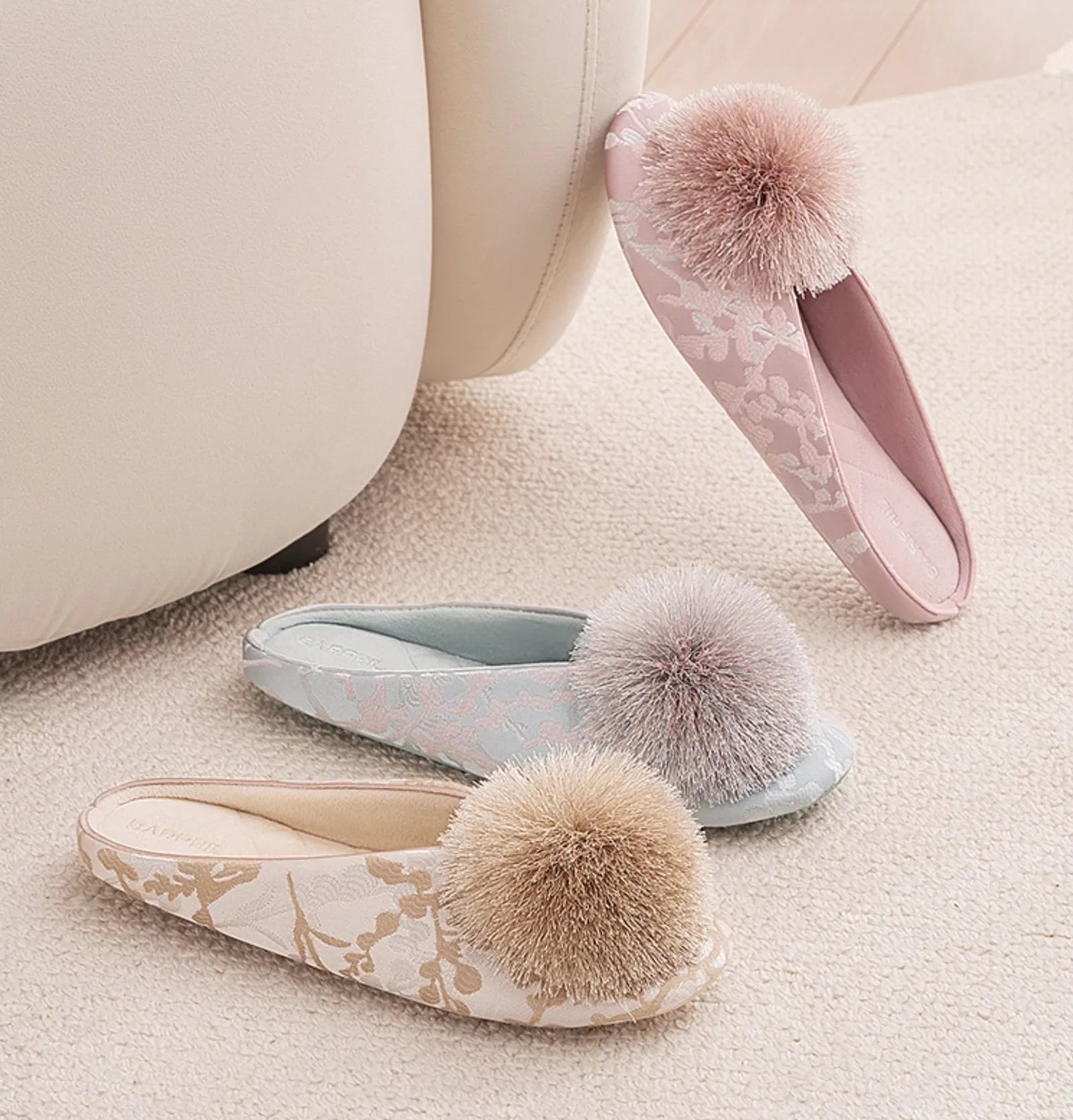 Group shot of blue pink and white floral jacquard house slippers with pom-poms - RoomDen
