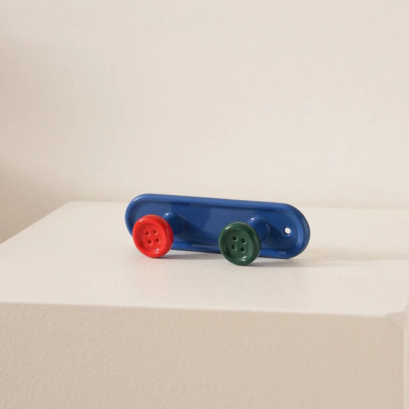Blue 2-hook button ceramic wall rack with red and green buttons on a white surface. - RoomDen