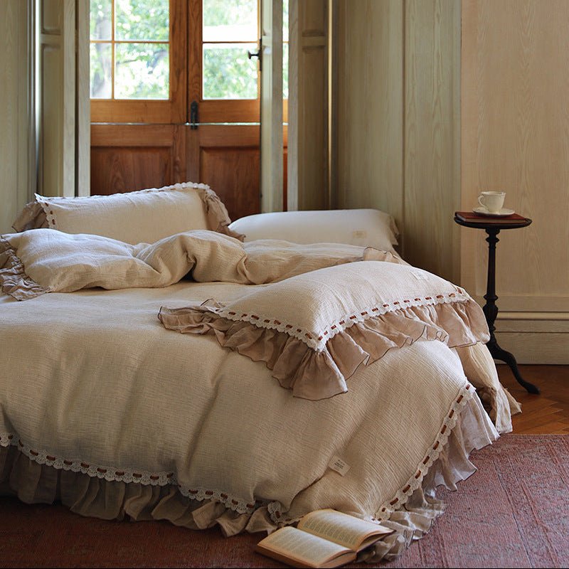 Elderfield Ruffle Lace Cotton-Linen Bedding Set – cream duvet and taupe ruffled pillows beside an open book - Roomden