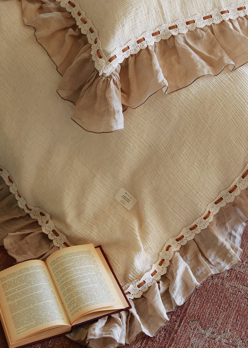 Elderfield Ruffle Lace Cotton-Linen Bedding Set – overhead view of cream fabric and taupe edging beside a book - Roomden