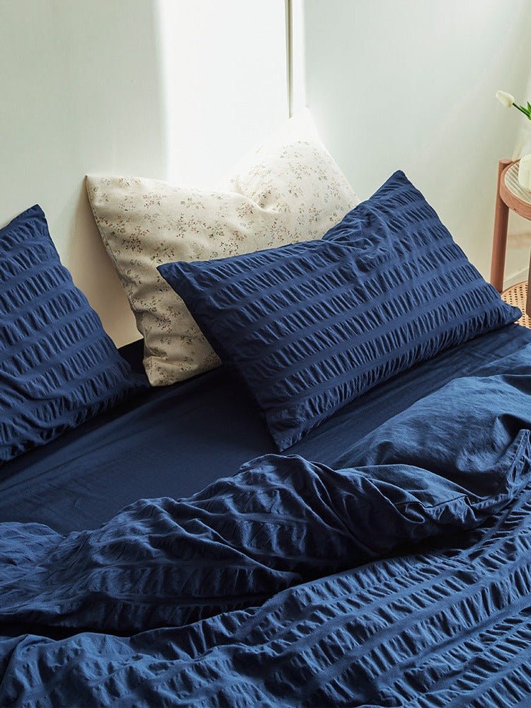 Marlon Seersucker Cotton Bedding Set – navy pillow propped above the textured duvet - Roomden