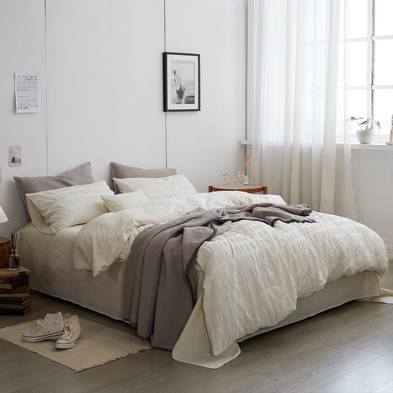 Marlon Seersucker Cotton Bedding Set – ivory bedding viewed from the side beside a bright window - Roomden