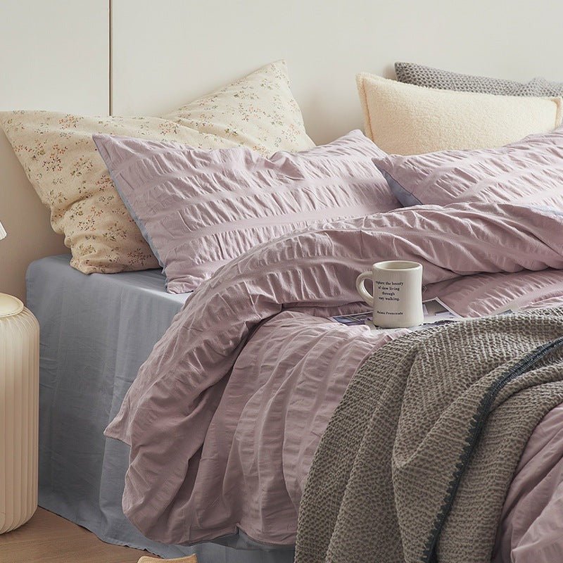 Marlon Seersucker Cotton Bedding Set – lilac-pink textured pillow and duvet folds beside a cup - Roomden