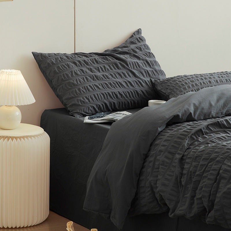 Marlon Seersucker Cotton Bedding Set – slate-grey pillows and duvet beside a white bedside table - Roomden
