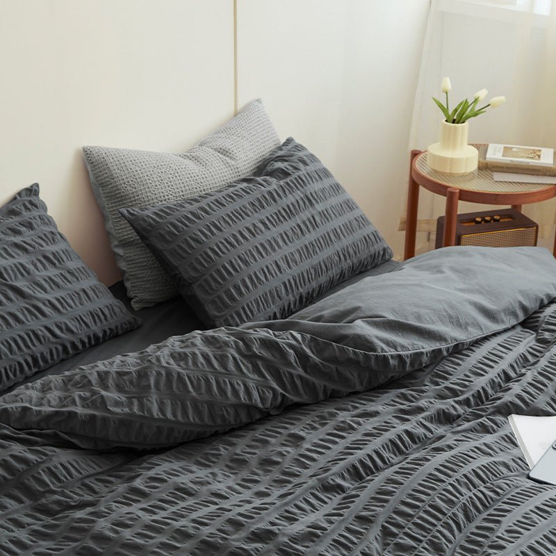 Marlon Seersucker Cotton Bedding Set – slate-grey bedding viewed from the side with a cup near the pillows - Roomden
