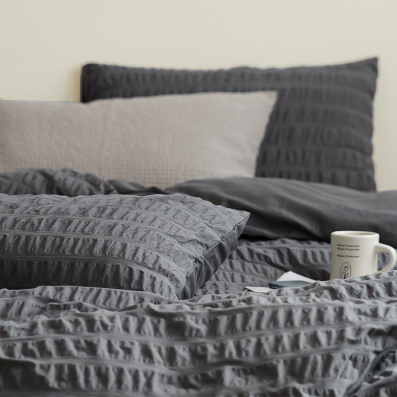 Marlon Seersucker Cotton Bedding Set – detail of slate-grey textured fabric beside a plain pillow - Roomden