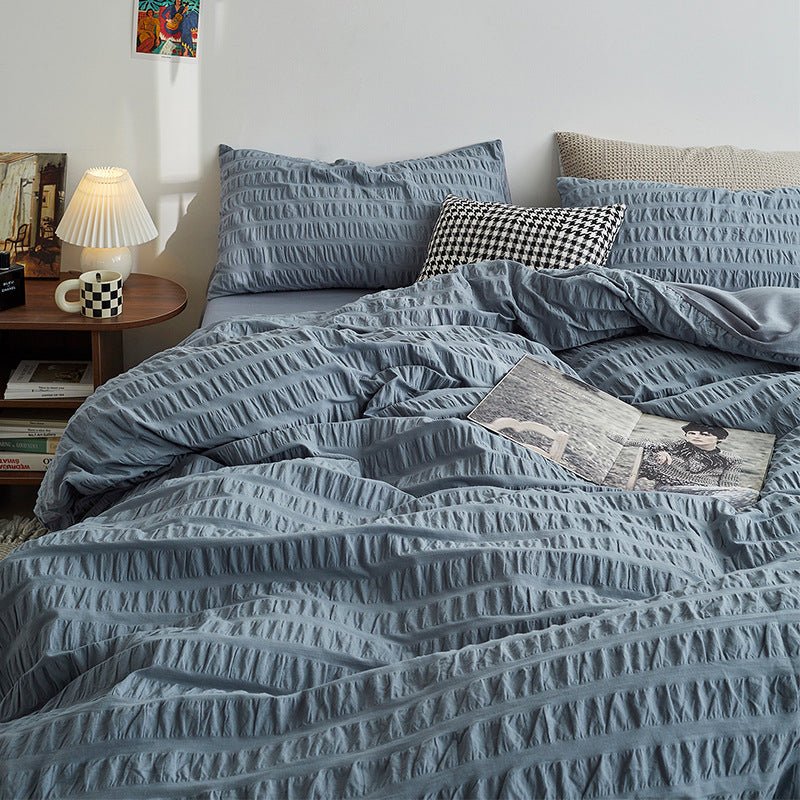 Marlon Seersucker Cotton Bedding Set – dusty-blue duvet spread below a row of pillows - Roomden