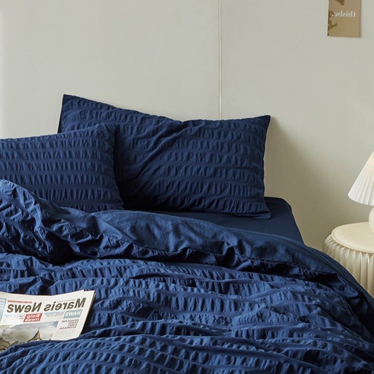 Marlon Seersucker Cotton Bedding Set – navy pillows and gathered folds viewed from the side - Roomden