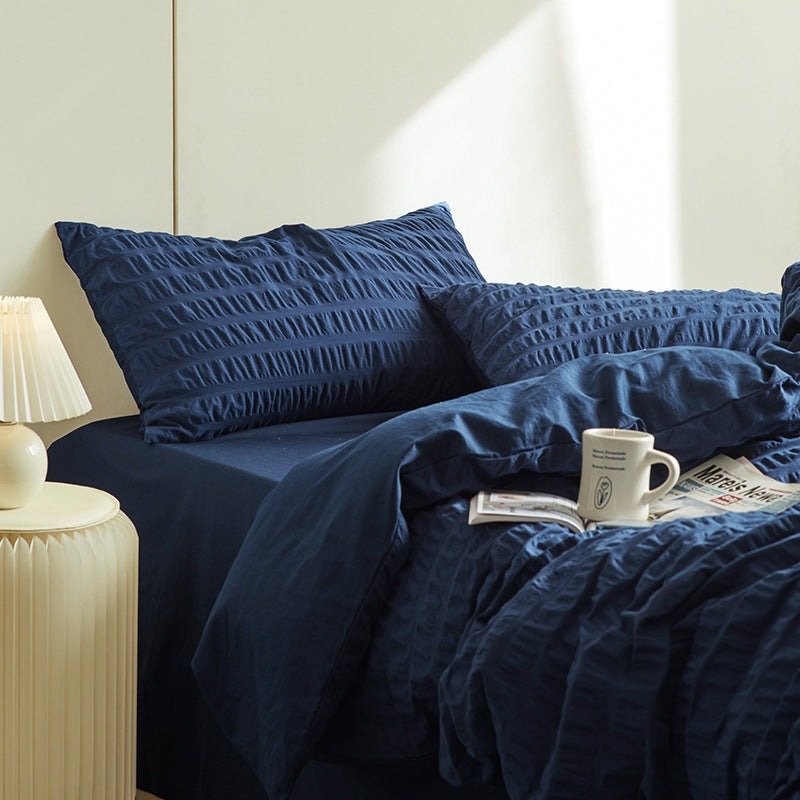 Marlon Seersucker Cotton Bedding Set – navy duvet and pillows in a shaft of sunlight - Roomden