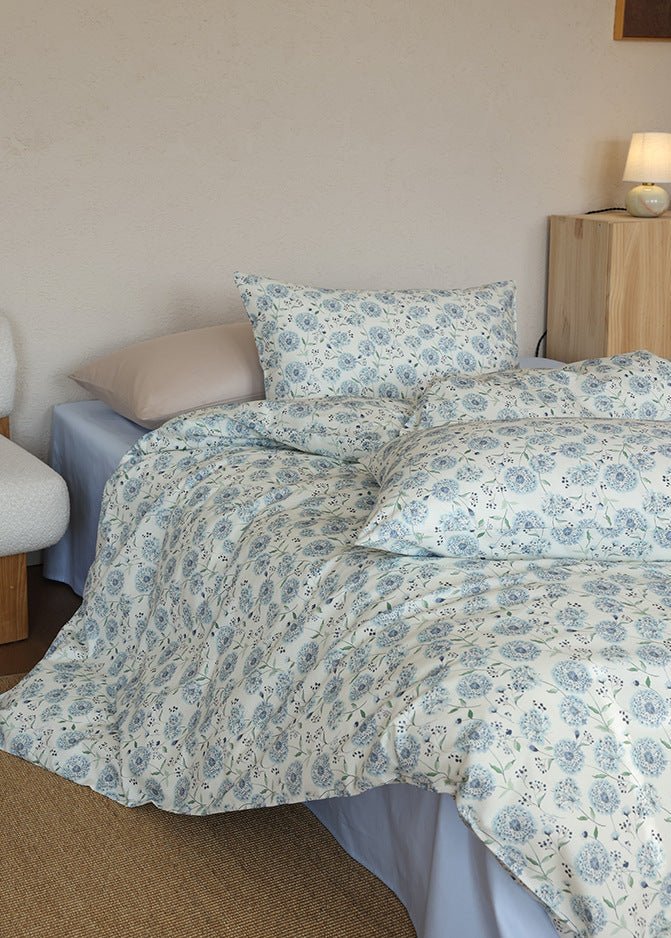 Verbena Botanical Cotton Bedding Set – blue floral duvet draped from a three-quarter bed angle - Roomden