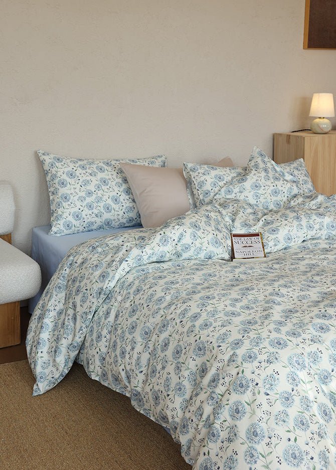 Verbena Botanical Cotton Bedding Set – side view of blue floral bedding beside a nightstand - Roomden