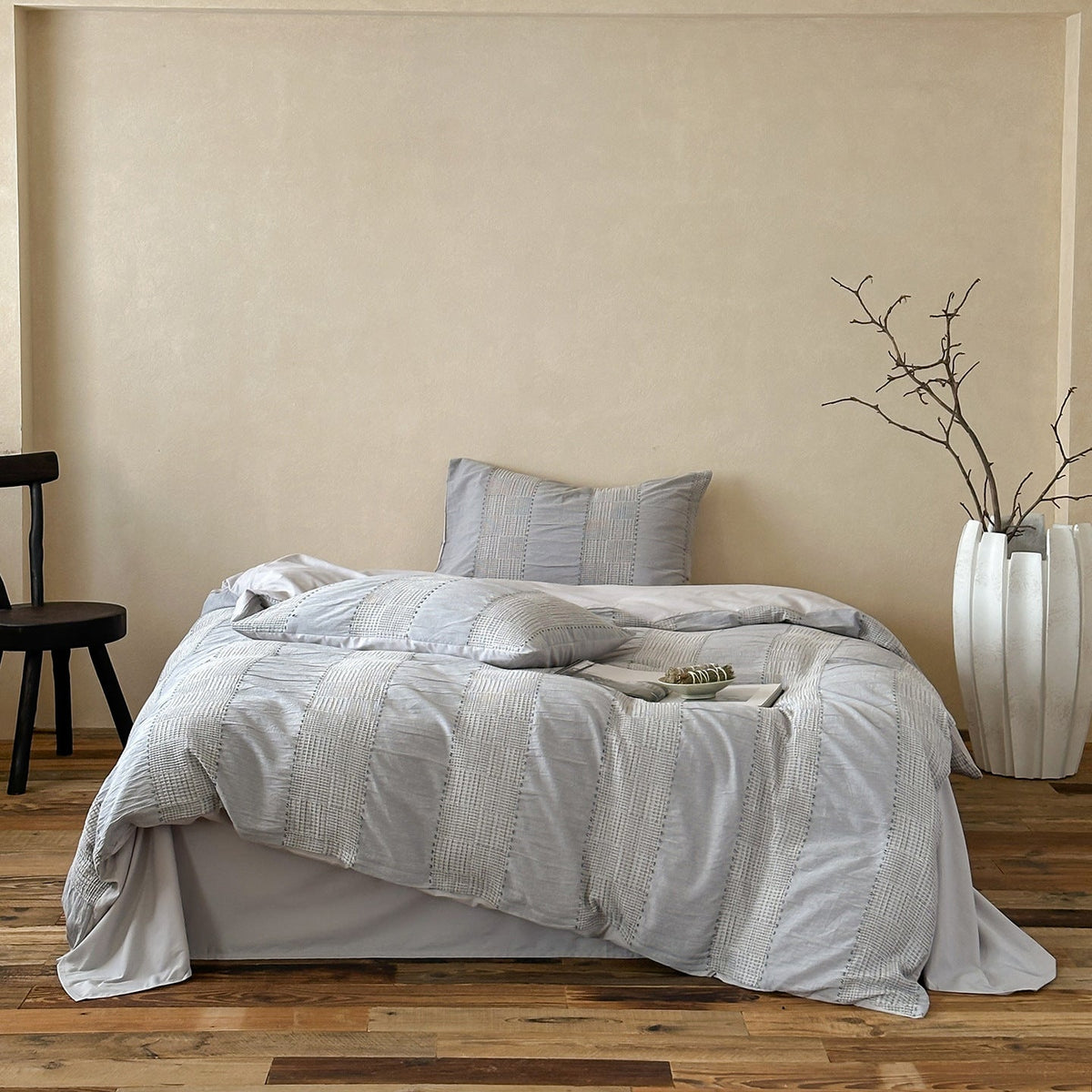 Solmere Striped Waffle-Weave Cotton Bedding Set – fog grey stripe full bed arranged beside a tall vase - Roomden
