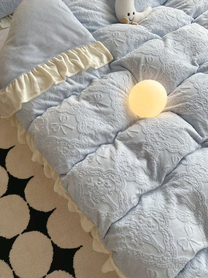 Soft pastel blue flannel bedding with cream trim and delicate bow patterns - RoomDen