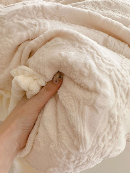 Close-up of plush flannel fleece fabric showing embossed bow and floral texture - RoomDen