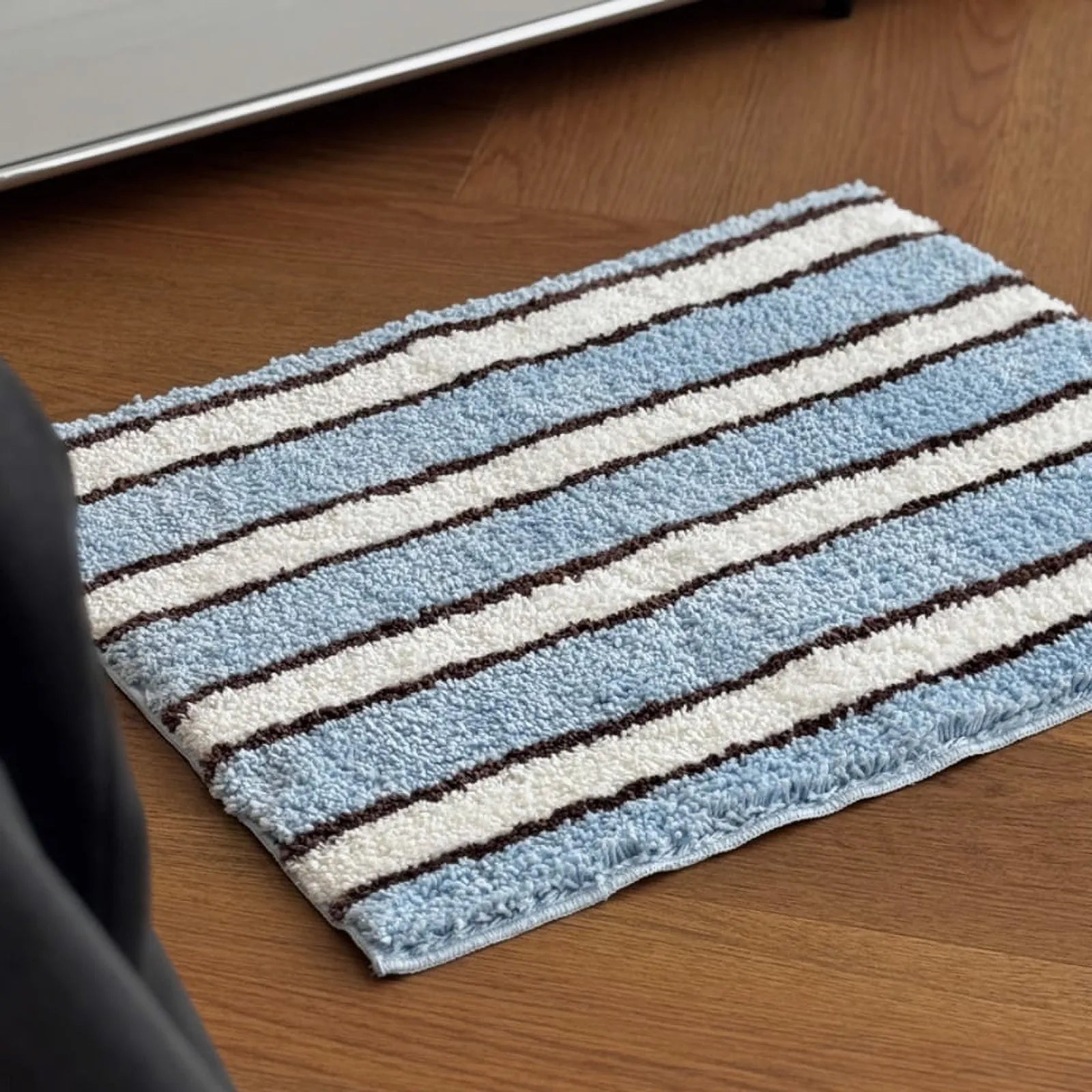 Full view of soft blue and white striped plush rug on wooden floor - RoomDen
