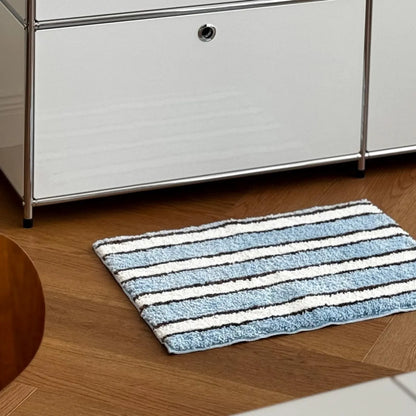 Blue striped accent rug placed under white minimalist cabinet - RoomDen