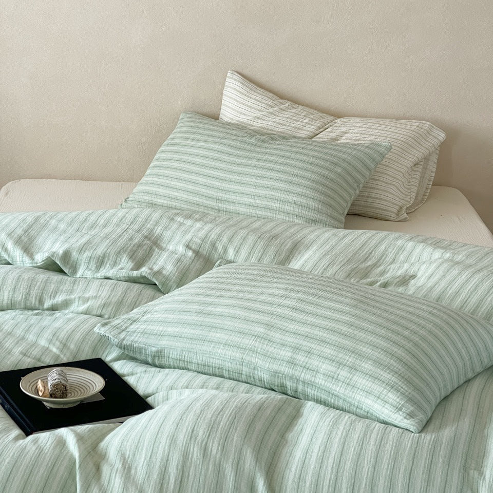 Halden Striped Cotton Double Gauze Bedding Set – near view of sage stripes and a tray beside the pillows - Roomden