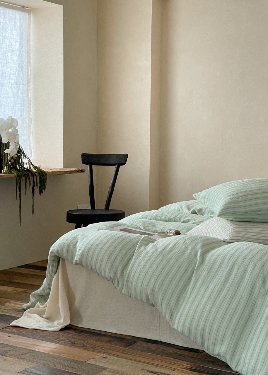 Halden Striped Cotton Double Gauze Bedding Set – side view of sage striped bedding near a window - Roomden