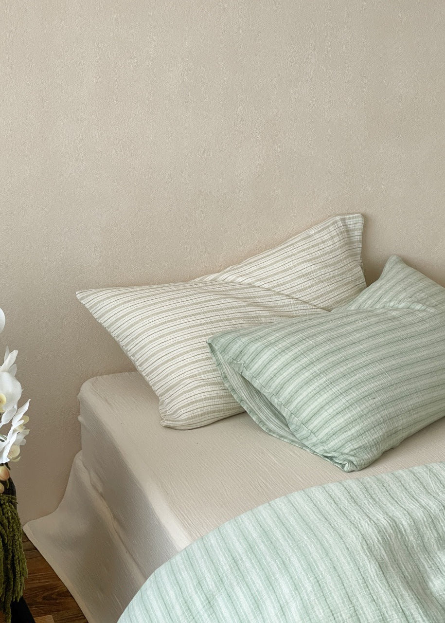 Halden Striped Cotton Double Gauze Bedding Set – overhead view of sage striped pillows on the bed - Roomden