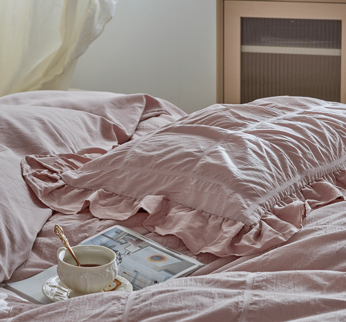 Odessa Ruffled Cotton Blend Bedding Set – close view of pink ruffles and folds beside a teacup - Roomden