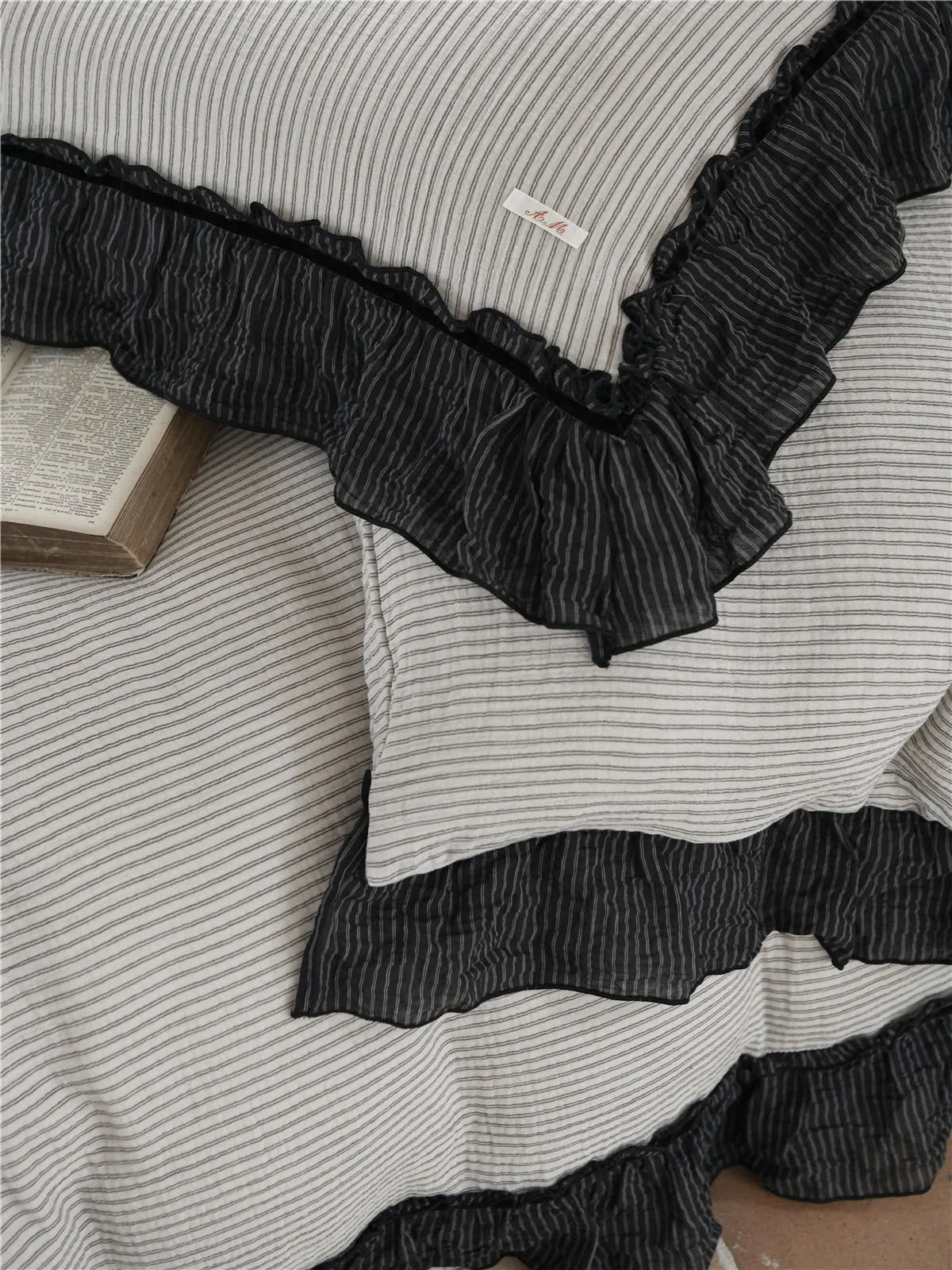Detailed top-down shot of the textured washed cotton pinstripe fabric and the crinkled black ruffle trim. - RoomDen