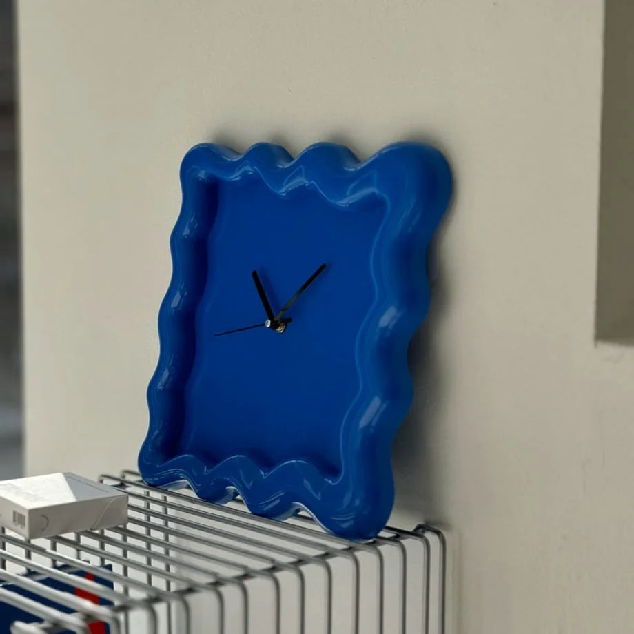 Angled detail shot of the glossy blue Wavy Squiggle Clock, showcasing its vibrant color and form. - RoomDen