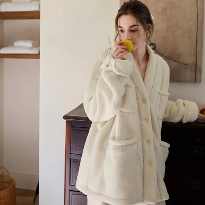 Model in the cream fleece pajama set leaning against a dresser while eating an apple, showing the side profile and pockets - RoomDen.