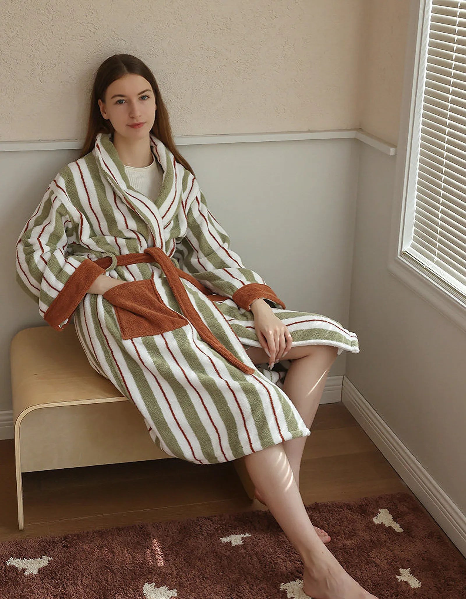 Model sitting relaxed on a bench wearing the vintage-style green and white striped robe.