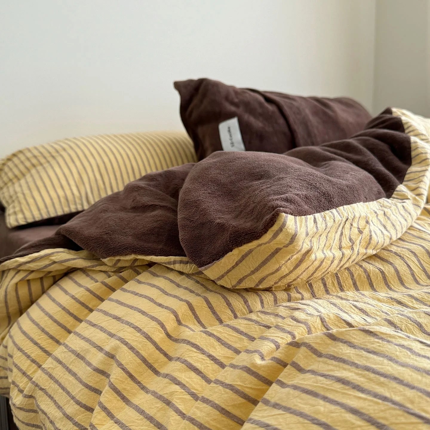 Angled view of the Brown & Yellow Striped Flannel Fleece Bedding Set, showing both sides.