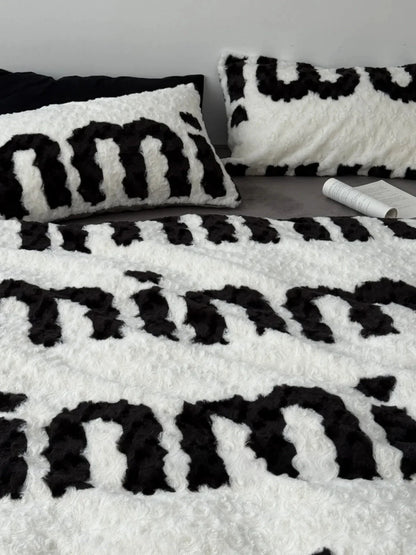 Top-down view showcasing the text pattern across the fuzzy flannel fleece duvet cover and matching pillowcases. - RoomDen