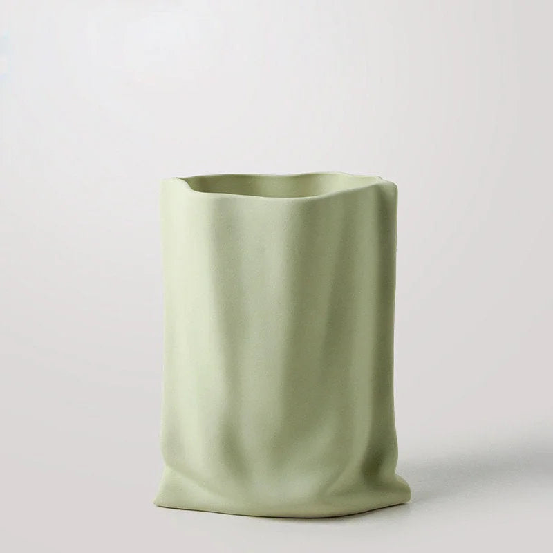 The Frosted Ruched Ceramic Paper Bag Vase in a soft Pistachio Green, showing its matte texture - RoomDen.