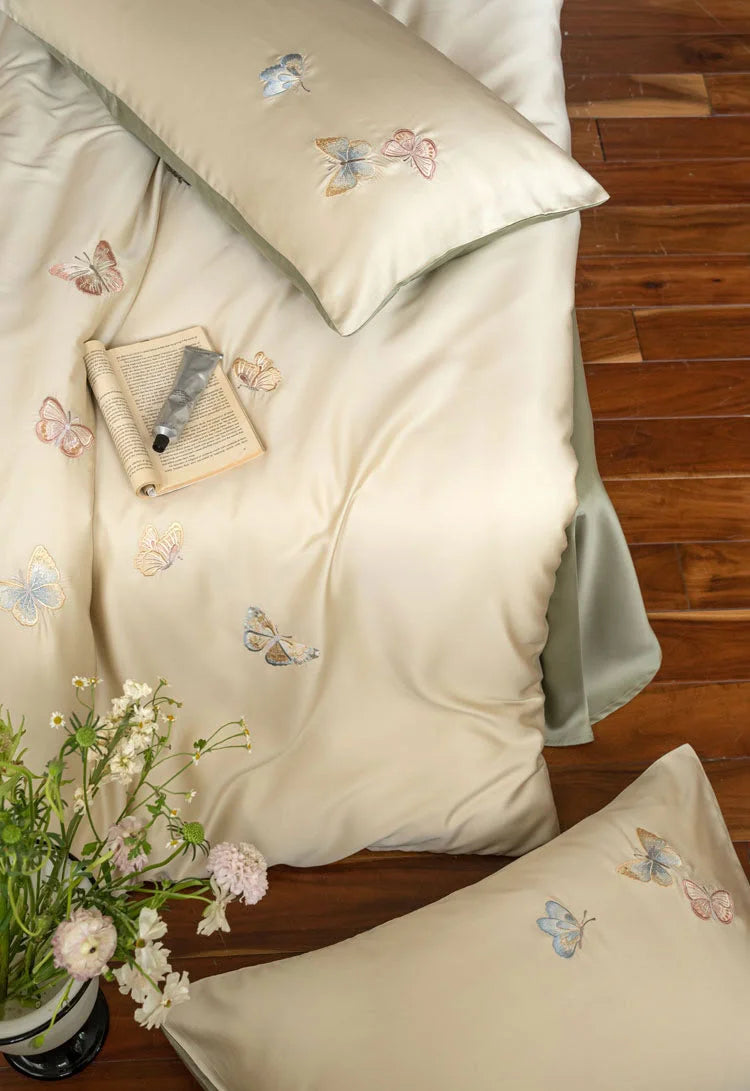 Top-down view of the bed, with flowers in the foreground, focusing on the scattered butterfly pattern.